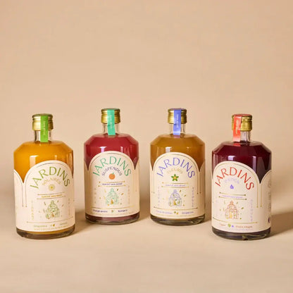 Vier bunte alkoholfreie Jardins-Flaschen aus 70 cl Glas mit bunten Deckeln und detailreichen Etiketten.