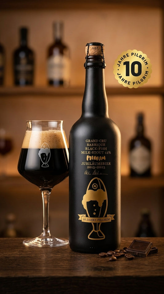 Mattschwarze 75 cl Flasche Jubiläumsbier 2025 Blackfish mit goldener Beschriftung neben gefülltem Bierglas auf Holztisch.